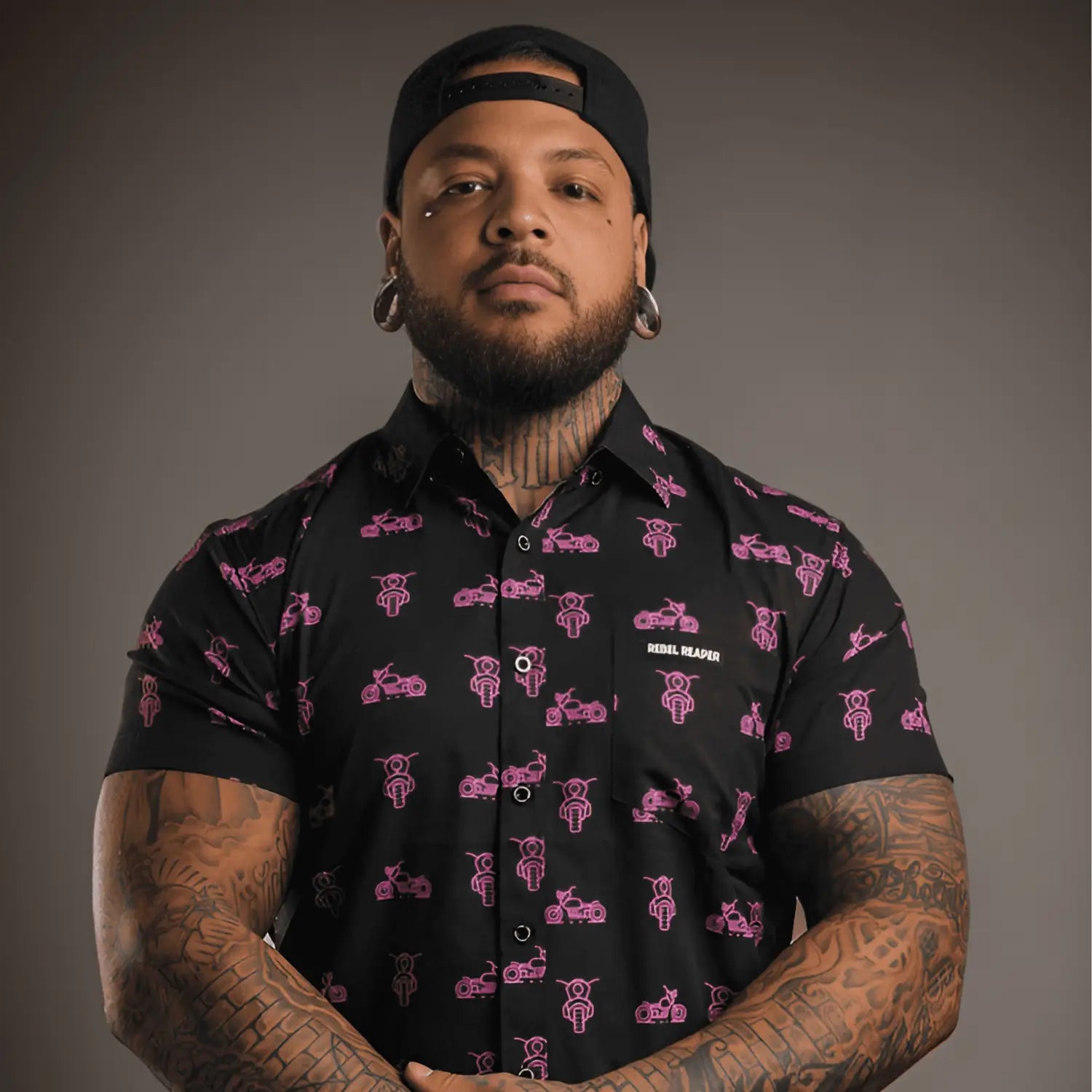 Man in Pink Neon Moto Button Up Shirt with motorcycle pattern and hidden collar buttons