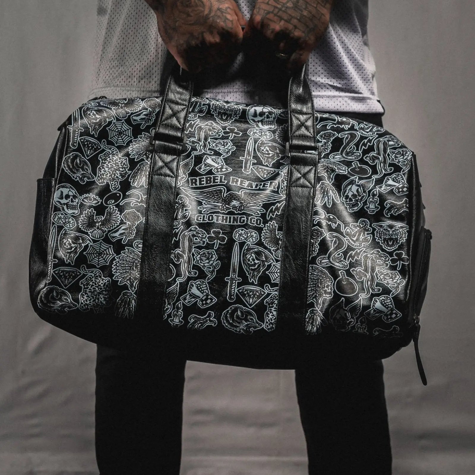 Black duffel bag with white tattoo-style graphics from the Bags collection for rebels