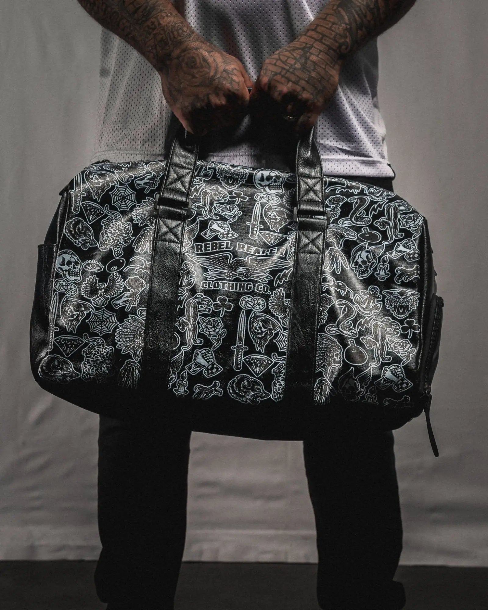 Black duffel bag with white tattoo-style graphics from the Bags collection for rebels