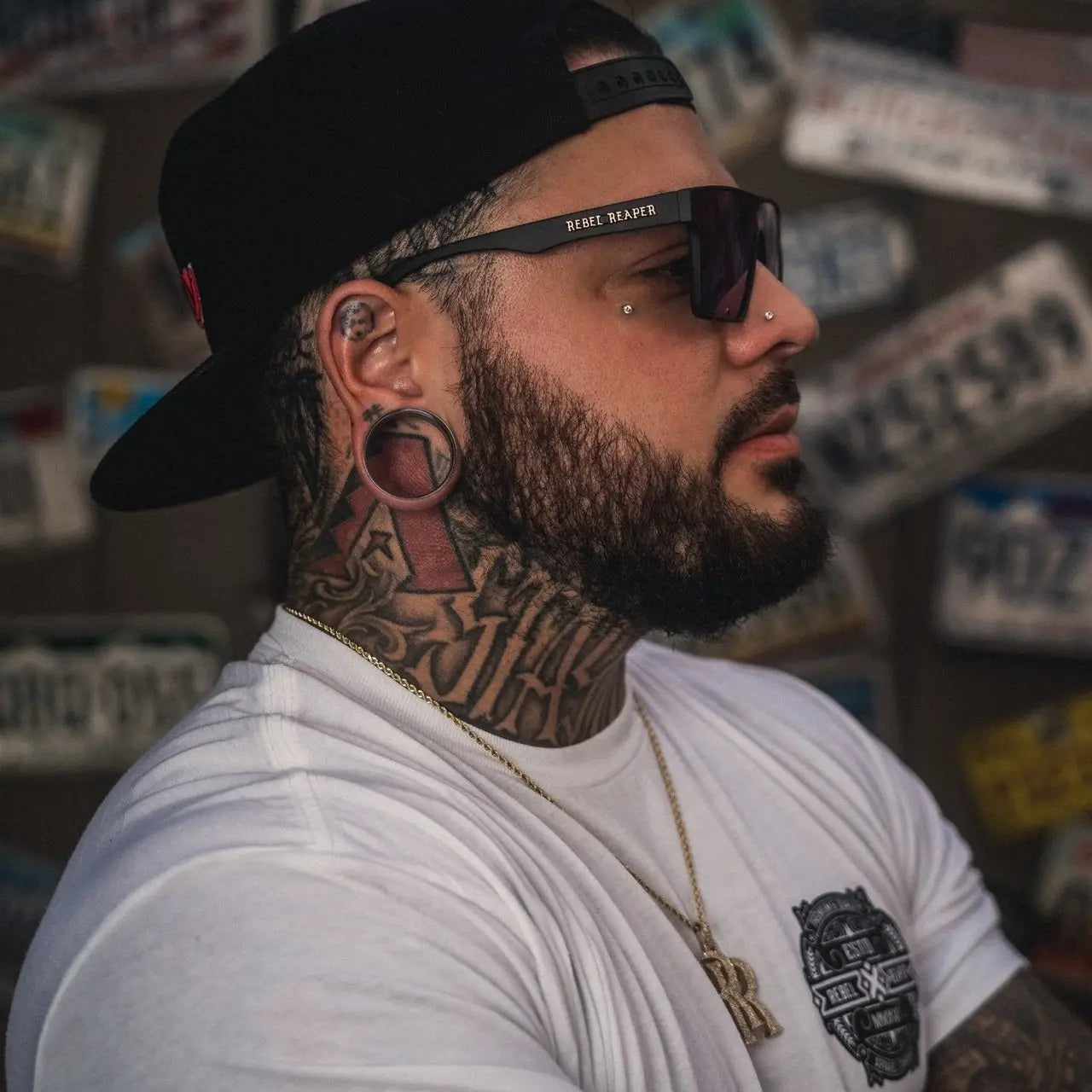 Man with tattoos and piercings wearing Rebel Reaper Hats clothing brand hat in collection