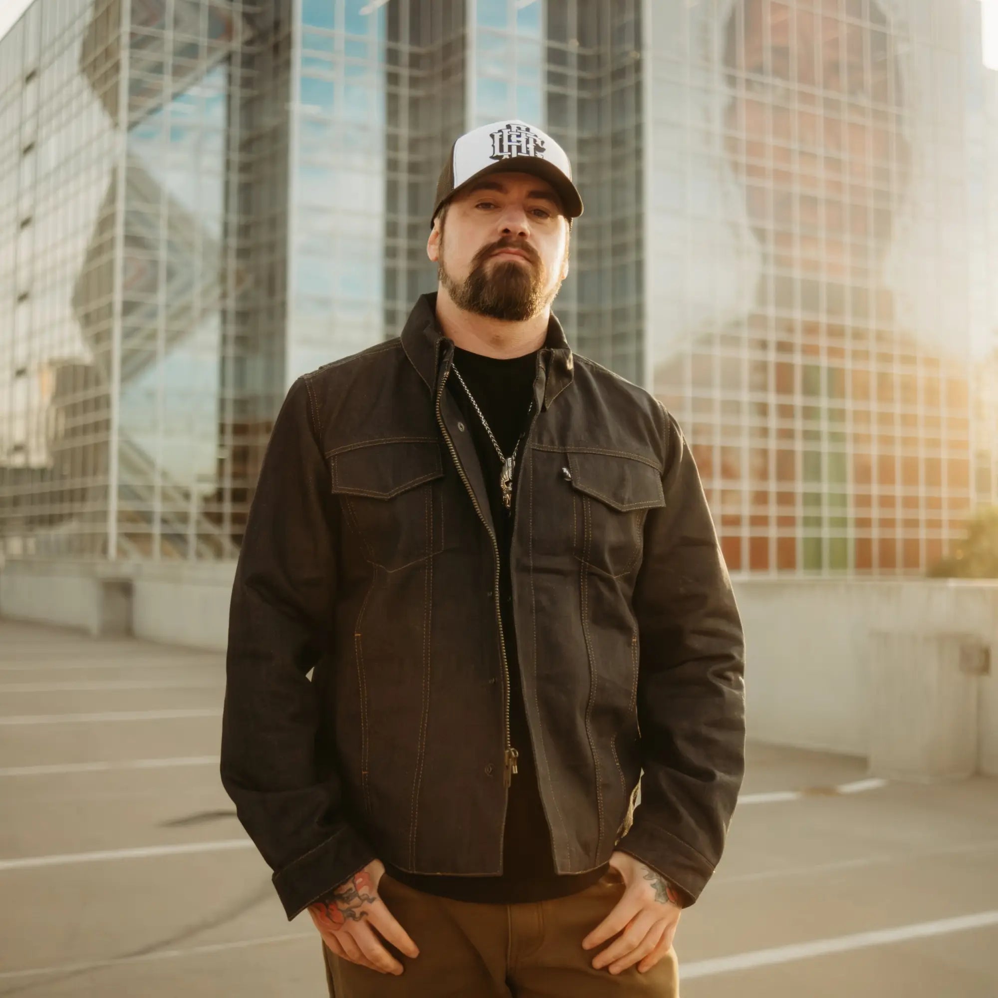 Man wearing a rebel reaper jacket and trucker hat in the Jackets collection