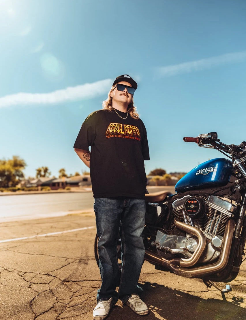 Man standing beside motorcycle wearing Rebel Reaper pants in the Pants & Shorts collection