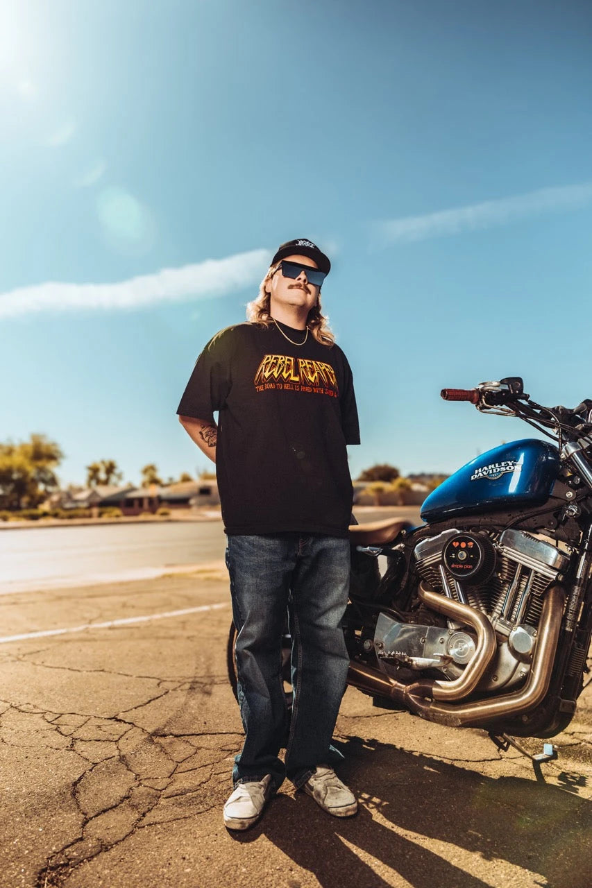 Man standing beside motorcycle wearing Rebel Reaper pants in the Pants & Shorts collection