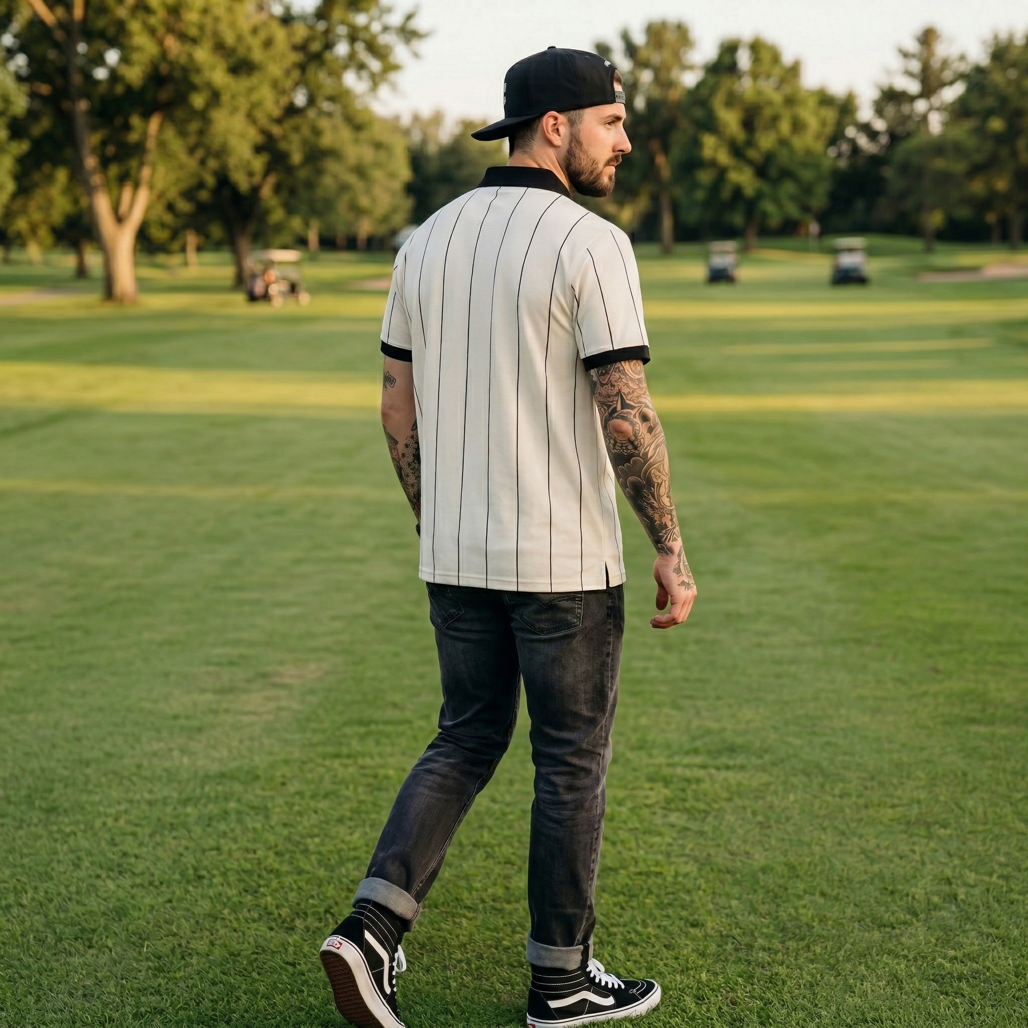 Man walking on a grassy field wearing a baseball uniform.