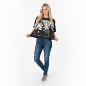 Woman wearing a black t-shirt with graphic design and blue jeans on a white background