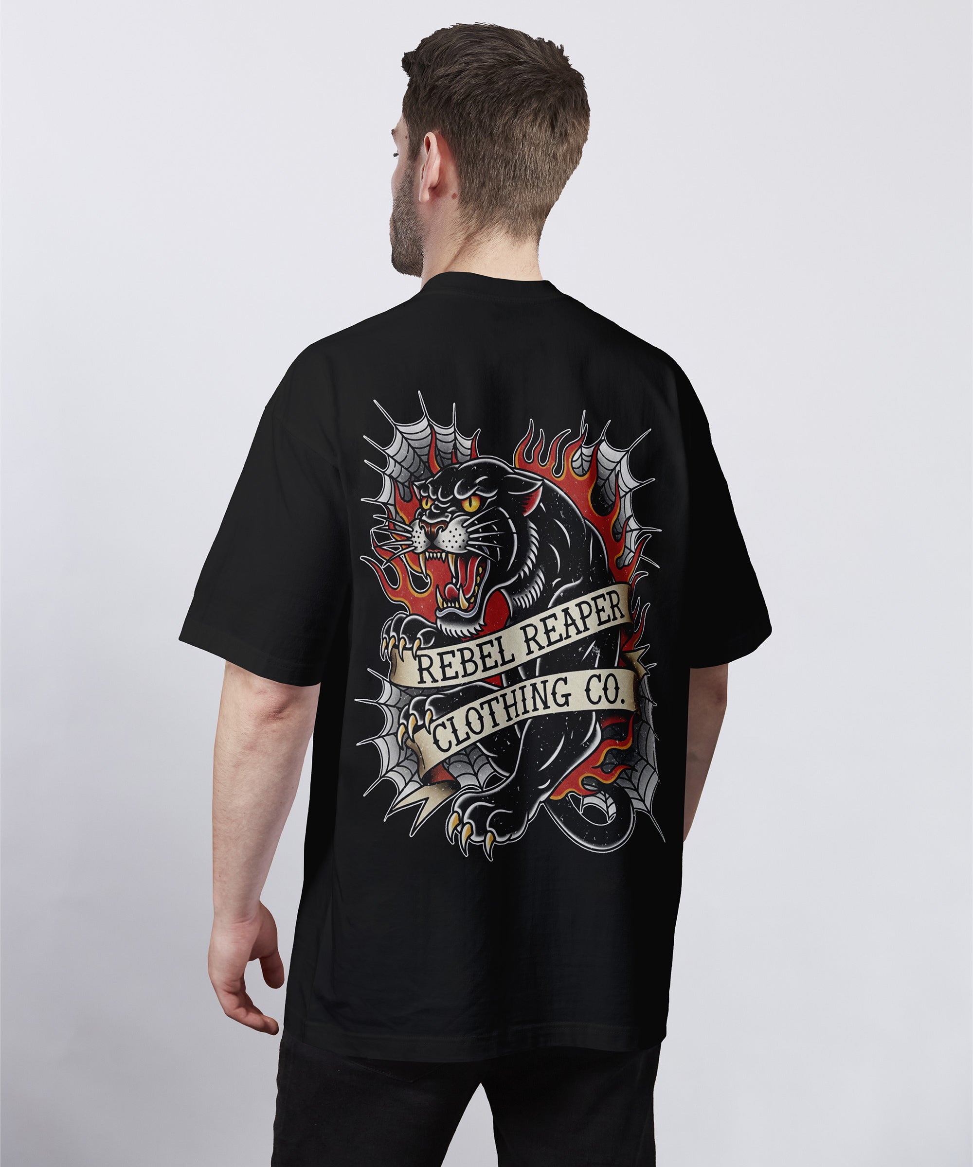 Man wearing a black t-shirt with a graphic design and 'Rebel Reaper Clothing Co.' text on the back.