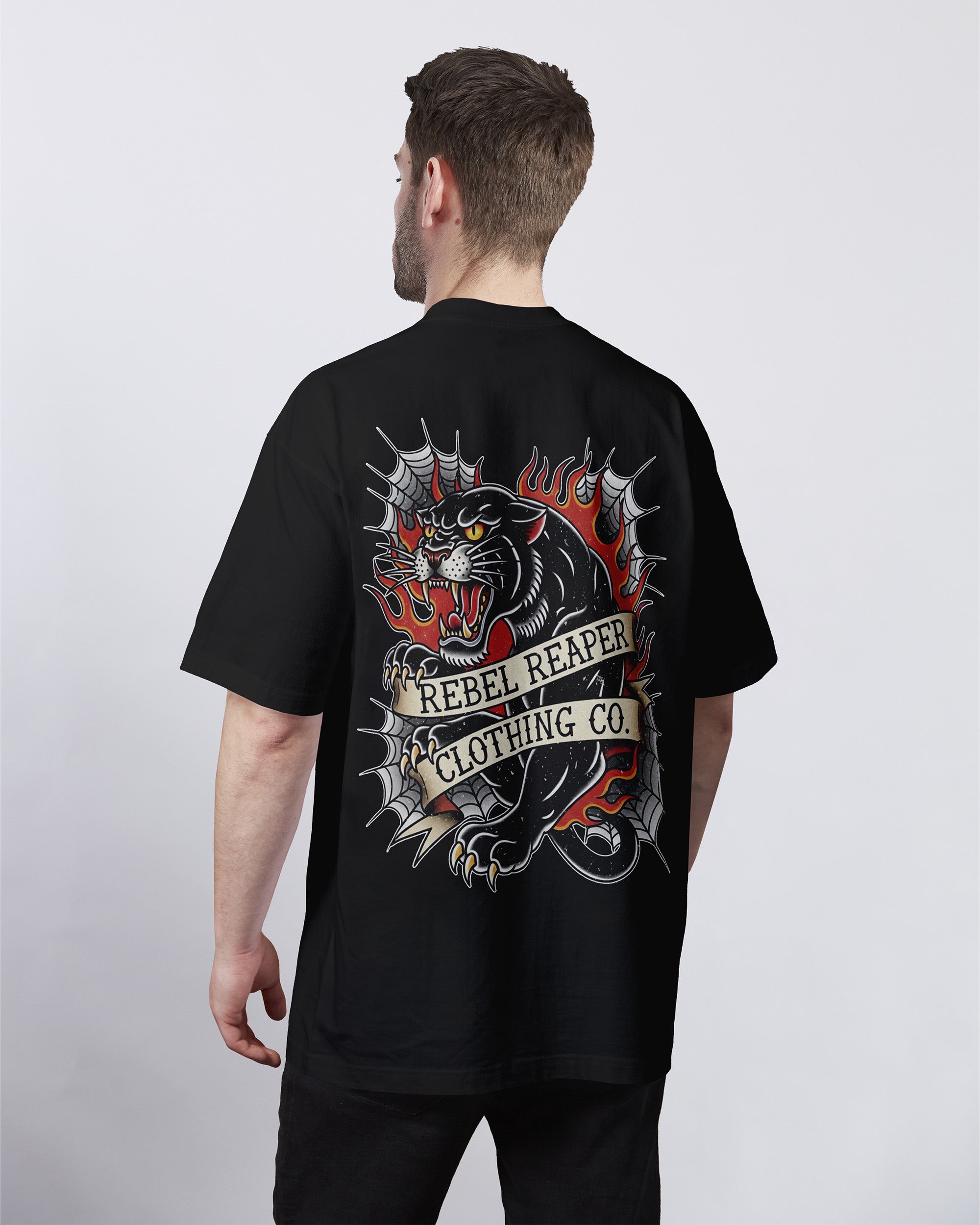 Man wearing a black t-shirt with a graphic design and 'Rebel Reaper Clothing Co.' text on the back.