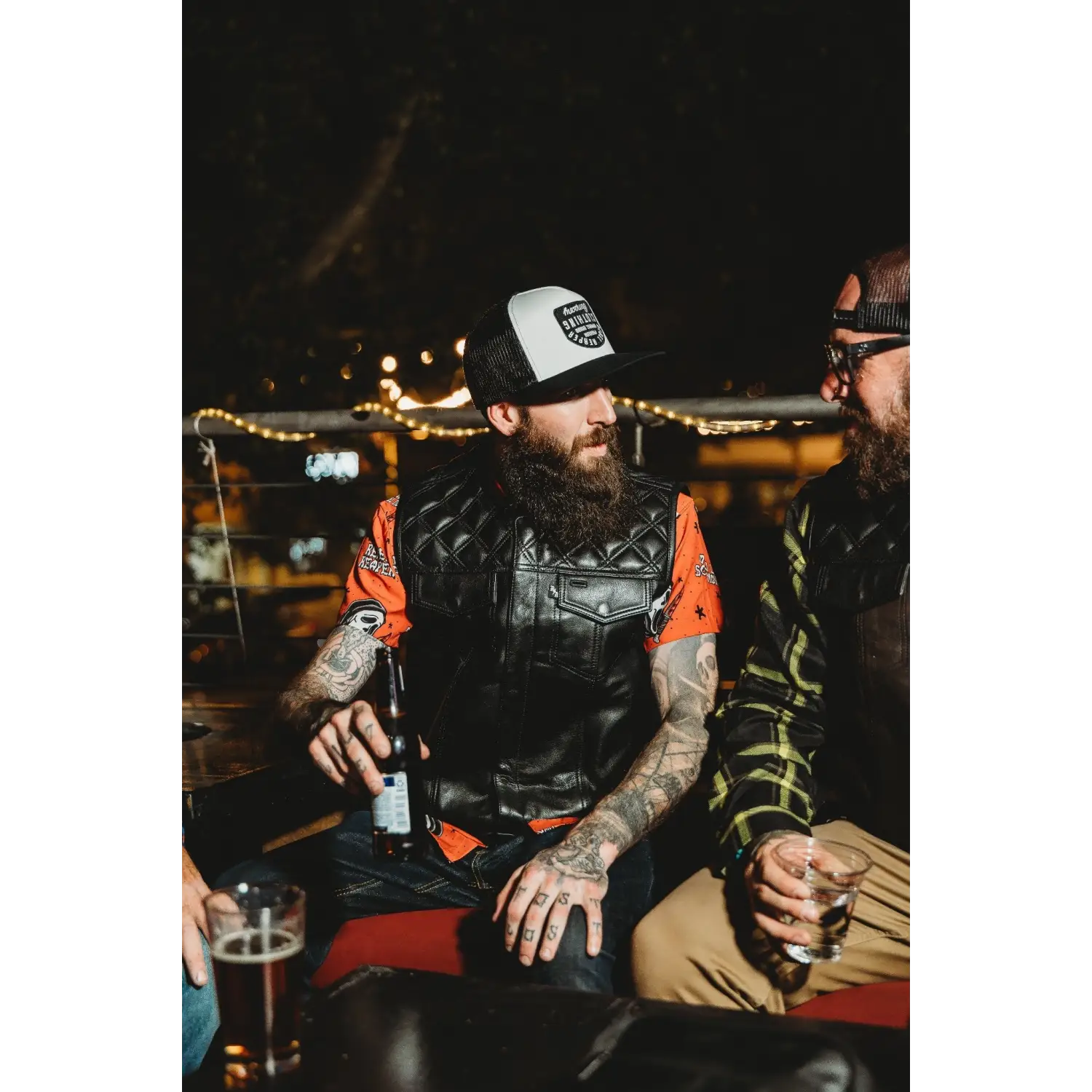 Bearded men with drinks wearing Back In Black Leather Vest with YKK zippers and cowhide leather carry pockets
