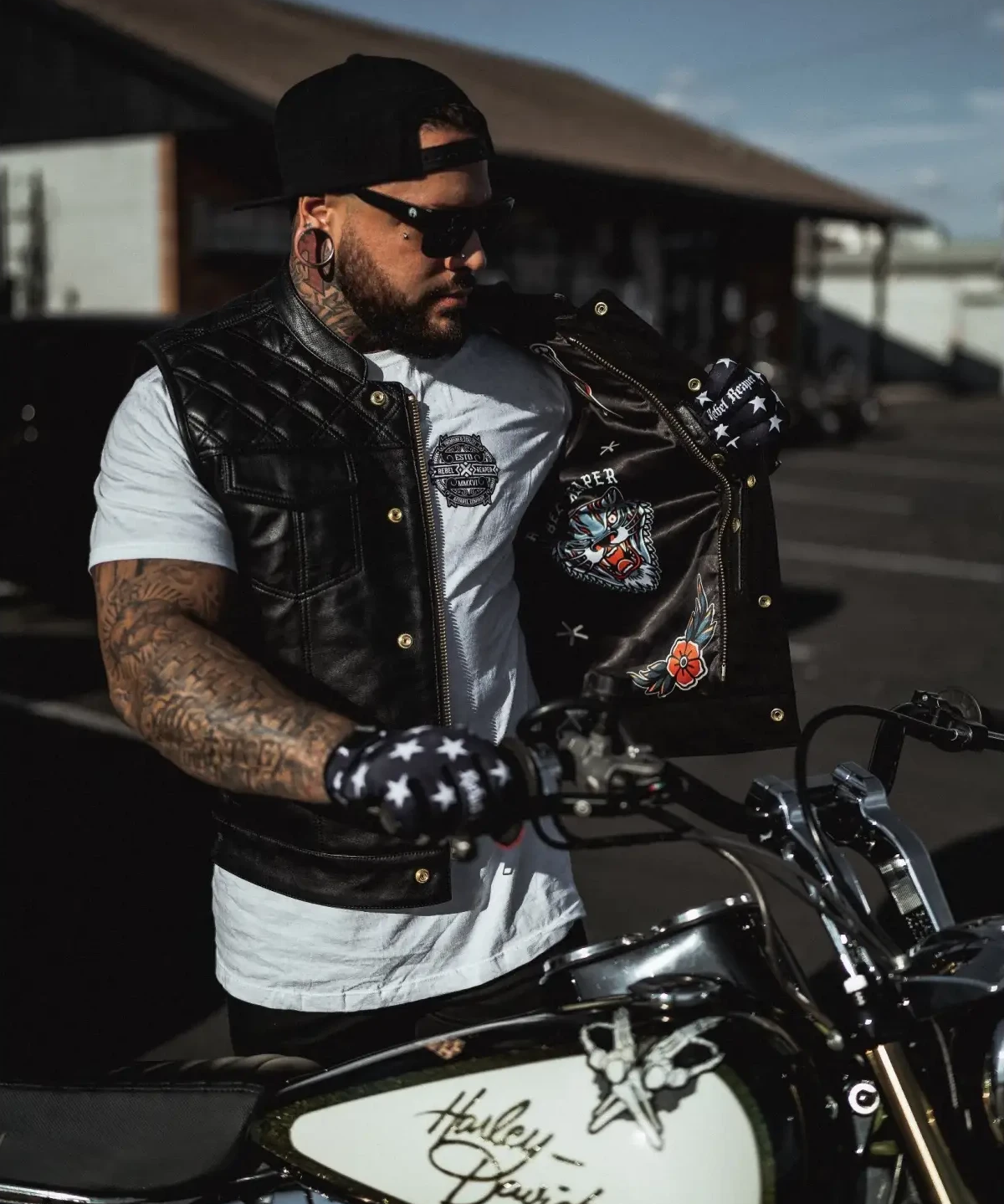 Biker with Harley-Davidson motorcycle wearing Back In Black Leather Vest featuring double diamond vest and YKK zippers