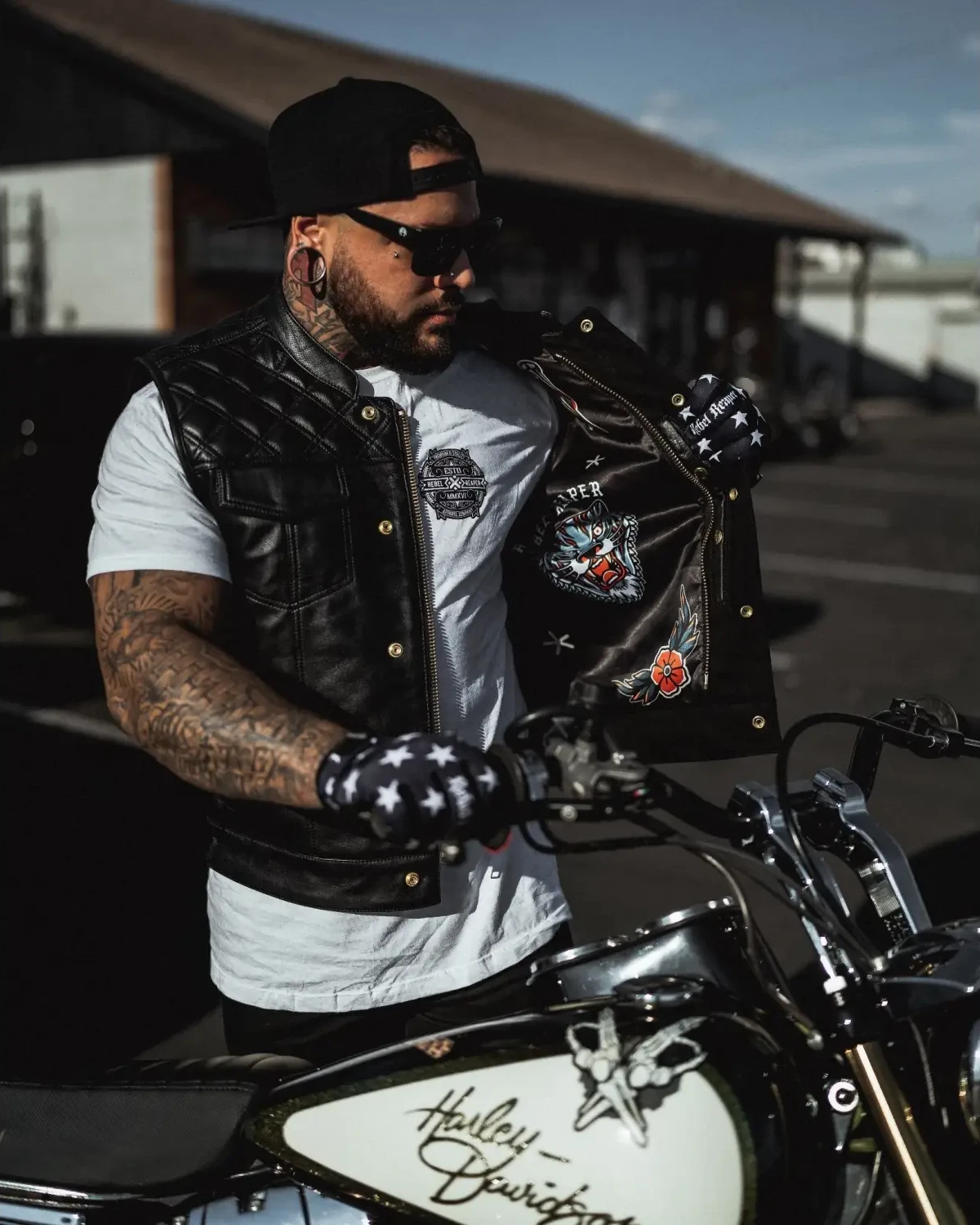 Biker with Harley-Davidson motorcycle wearing Back In Black Leather Vest featuring double diamond vest and YKK zippers