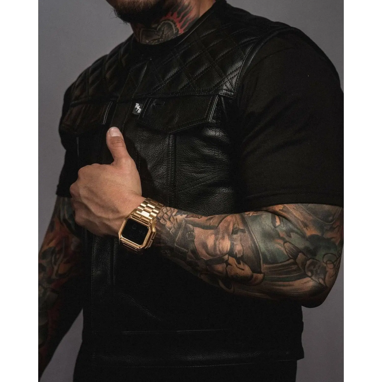 Gold smartwatch with metal band on Back In Black Leather Vest for short torso and double diamond vest style