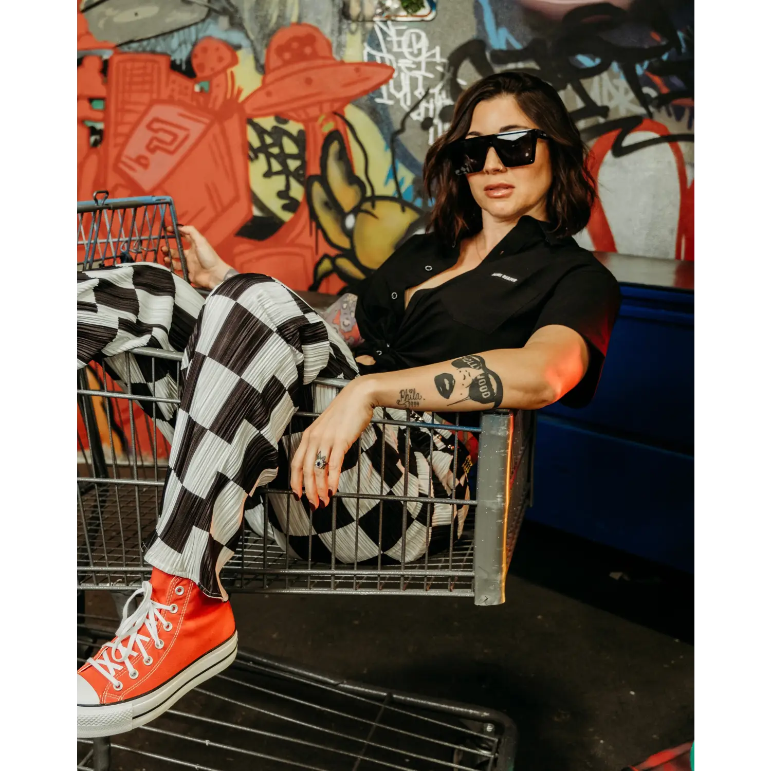 Woman in checkered pants and red sneakers wearing Black Bamboo Button Up Shirt with wrinkle-resistant fabric