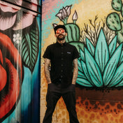 Man in black bamboo short sleeve button-up shirt with hidden collar buttons and wrinkle-resistant fabric