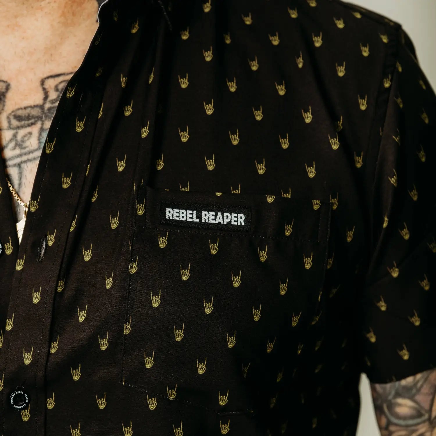Black shirt with yellow metal hands and rock hand pattern featuring hidden collar buttons