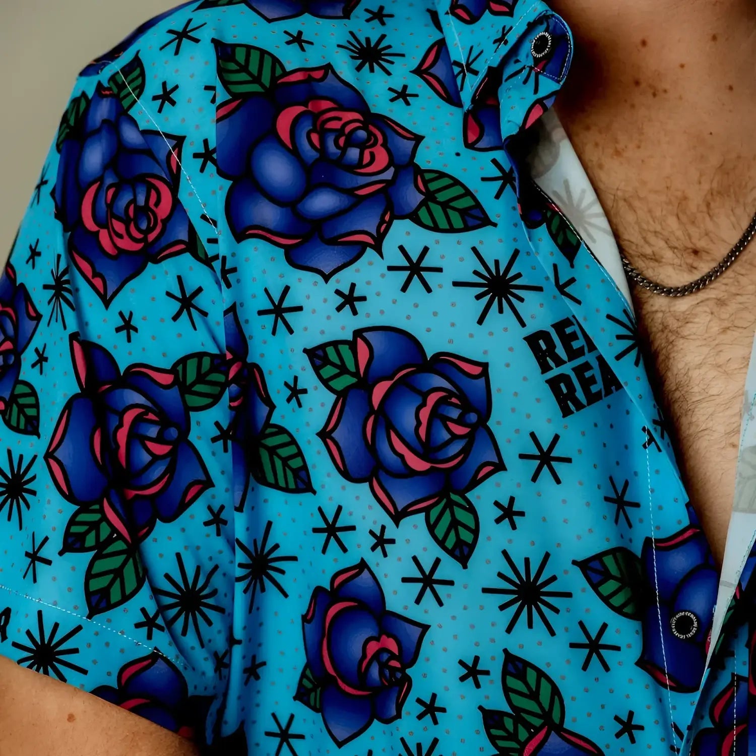 Blue Flash of Roses blue short sleeve button-up shirt with bold purple roses pattern