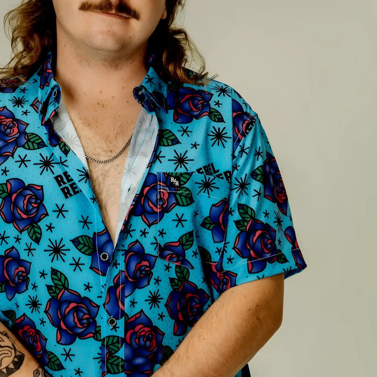 Blue floral short-sleeve shirt with bold purple roses for a stylish sleeve button-up look