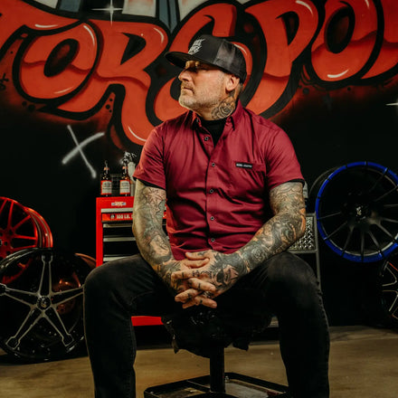 Tattooed man in a Burgundy Bamboo Button Up Shirt S/S with wrinkle-resistant bamboo fabric