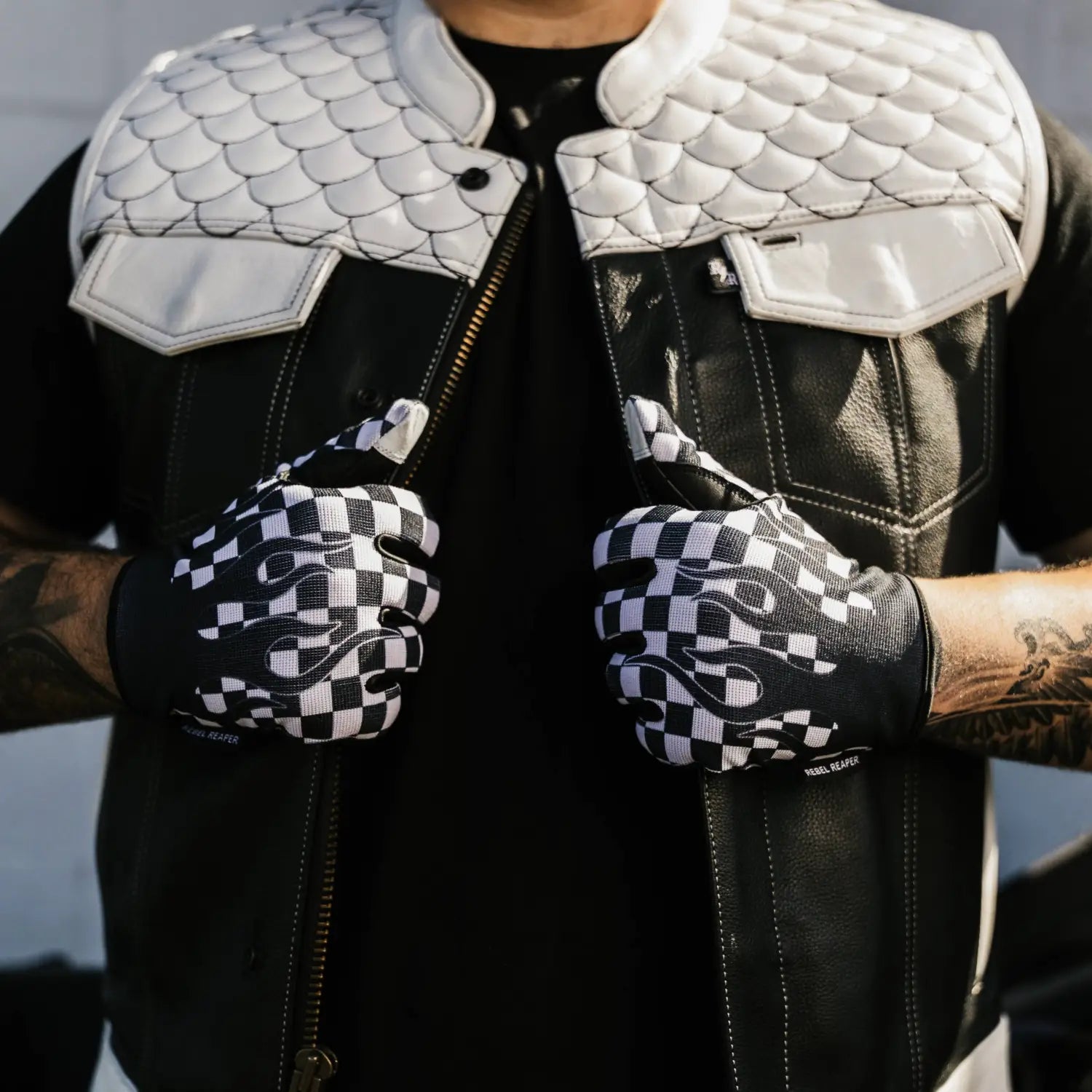 Black leather vest with white quilted shoulders and checkered flames moto gloves