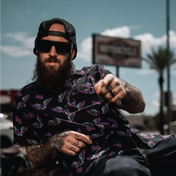 Bearded man in patterned shirt wearing Dana Retro Squared sunglasses with Rebel Reaper design and UV400 protection