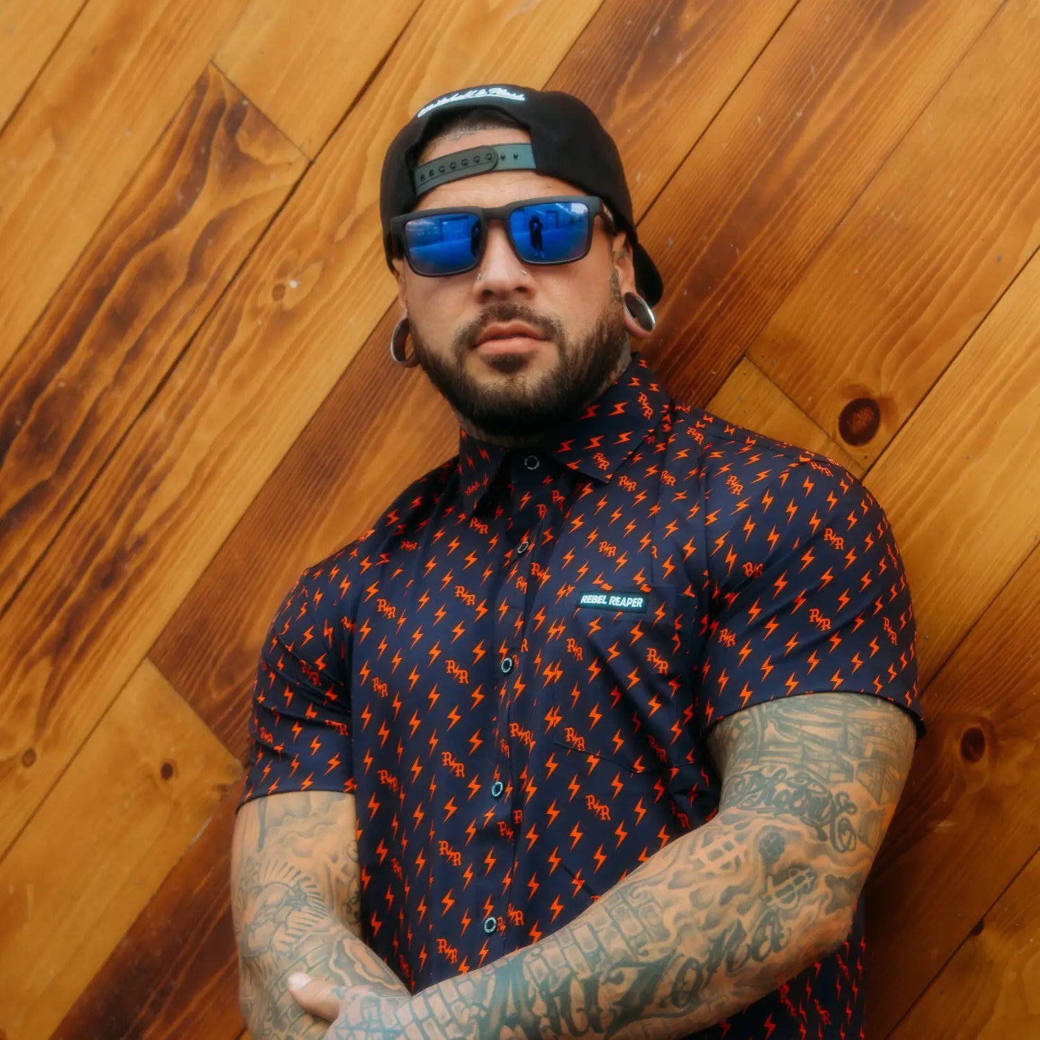 Man in patterned shirt wearing Dillinger Squared UV400 sunglass with interchangeable arms