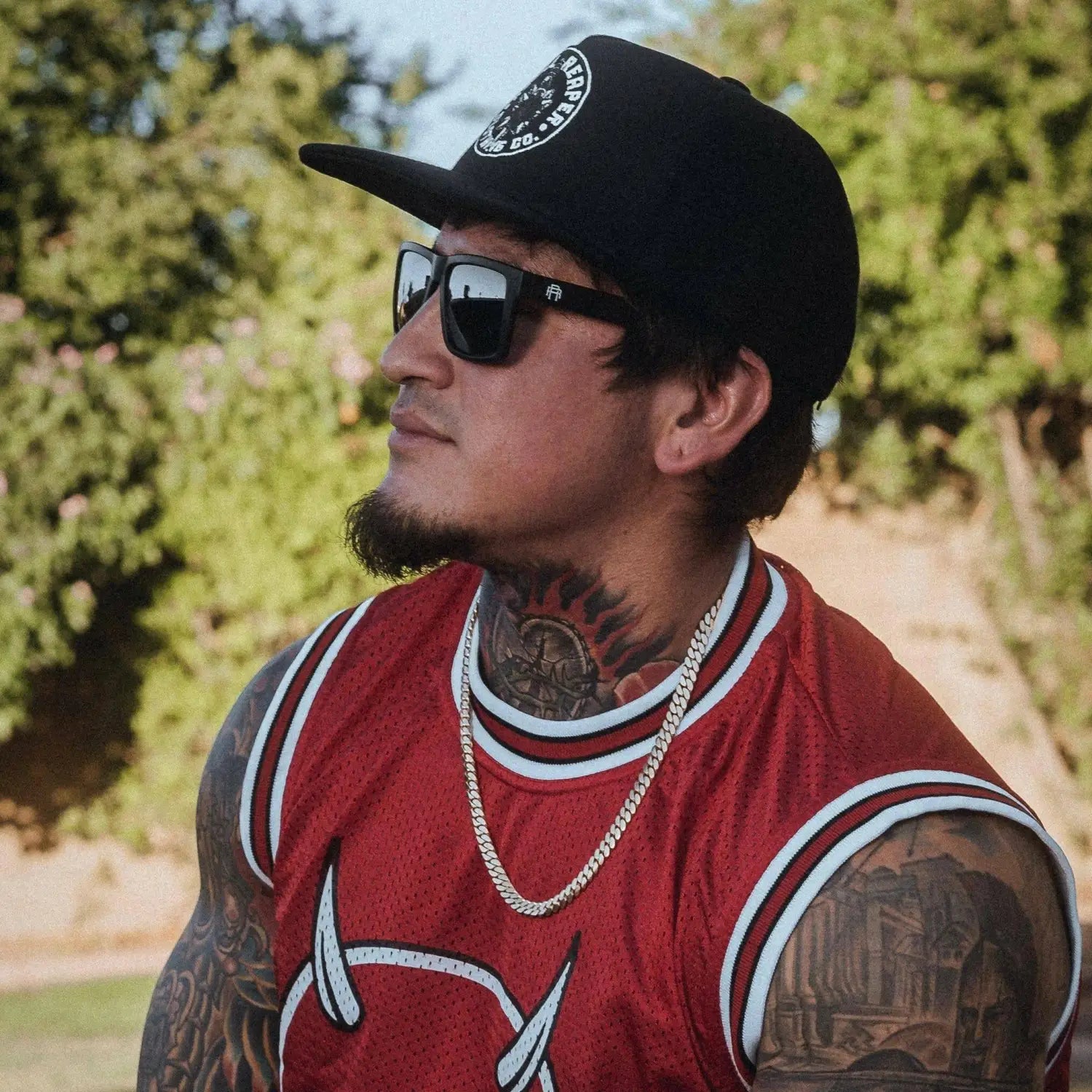 Man with tattoos wearing Dillinger Squared UV400 sunglasses with interchangeable arms and polarized lenses