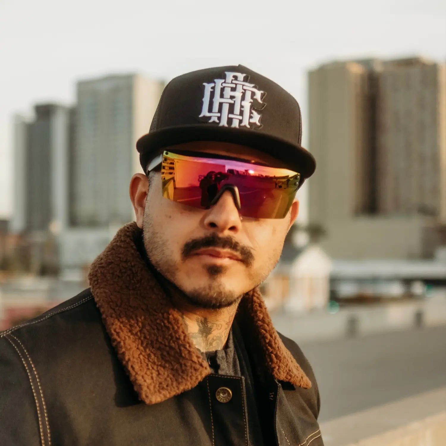 Man wearing Hogan Reflective UV Blocking Sunglass Collection with rebel reaper tattoo
