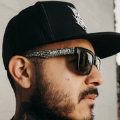 Black sunglasses with patterned frames from Hustler Wayfarer Sunglass Collection featuring signature rebel reaper and interchangeable arms