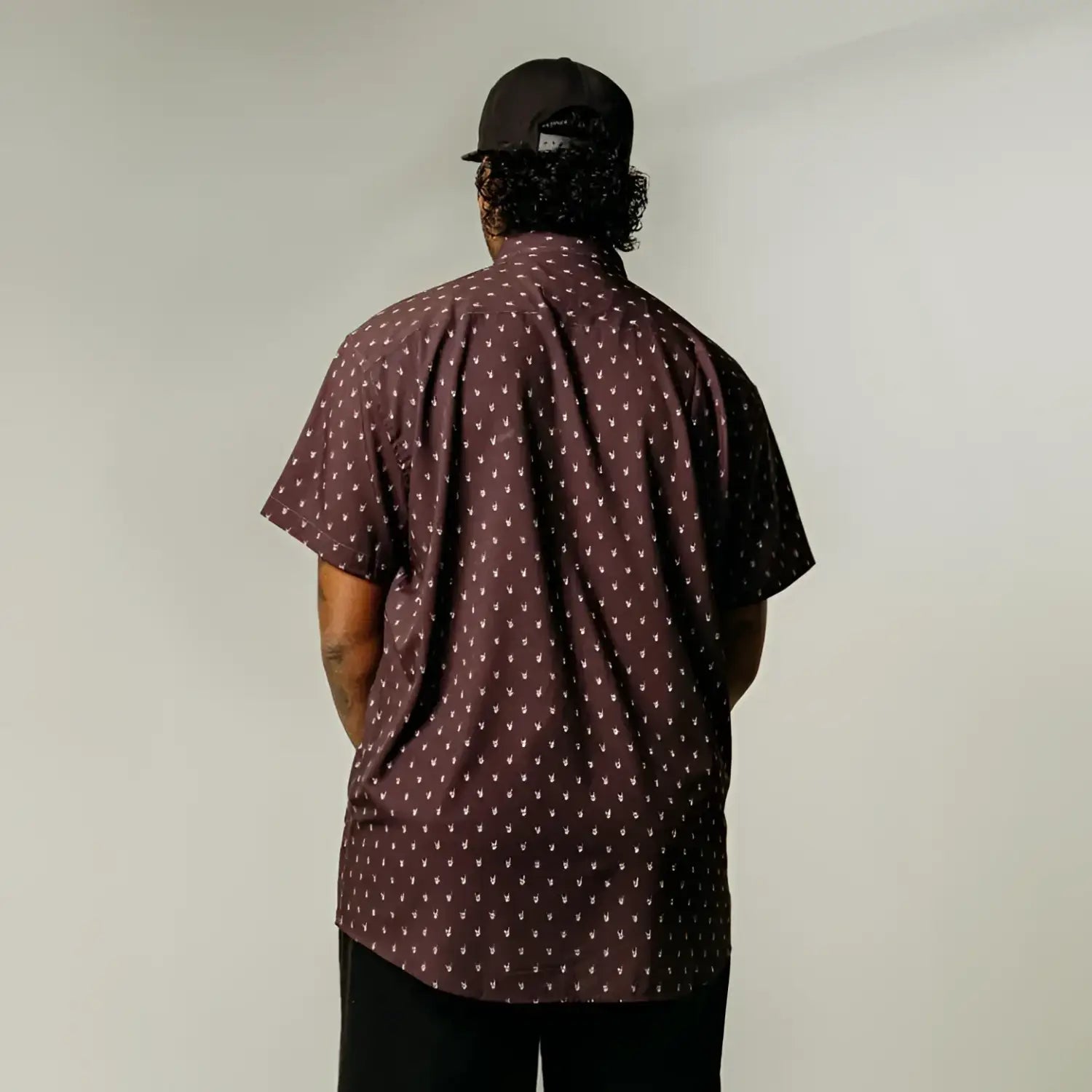 Man in patterned shirt with hidden collar buttons and wrinkle-resistant fabric, Midnight Metal Hands product