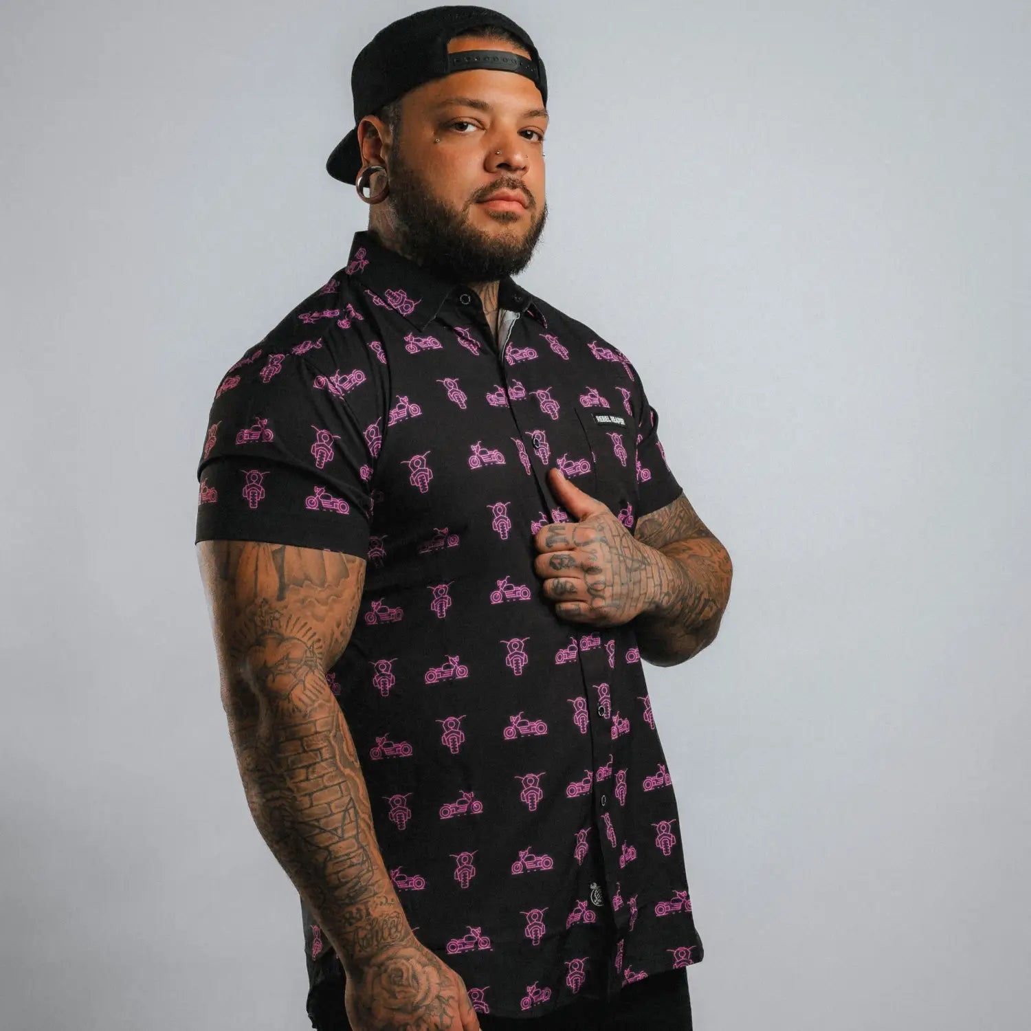 Pink Neon Moto Button Up Shirt featuring black motorcycle pattern with wrinkle-resistant fabric and hidden collar buttons for a polished appearance