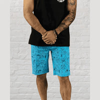 Man wearing blue tattoo flash boardshorts with eco-conscious fabric casual wear and velcro pockets