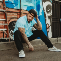 Tattooed man wearing Teal Bamboo Button Up Shirt with hidden collar buttons and wrinkle-resistant bamboo short sleeve fabric