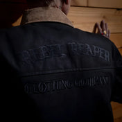 Black jacket with embroidered text from The Scythe Jacket Black Denim, premium selvedge denim style