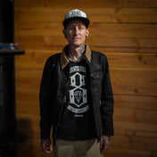 Tattooed man wearing The Scythe Jacket Black Denim with conceal carry pockets and premium selvedge denim