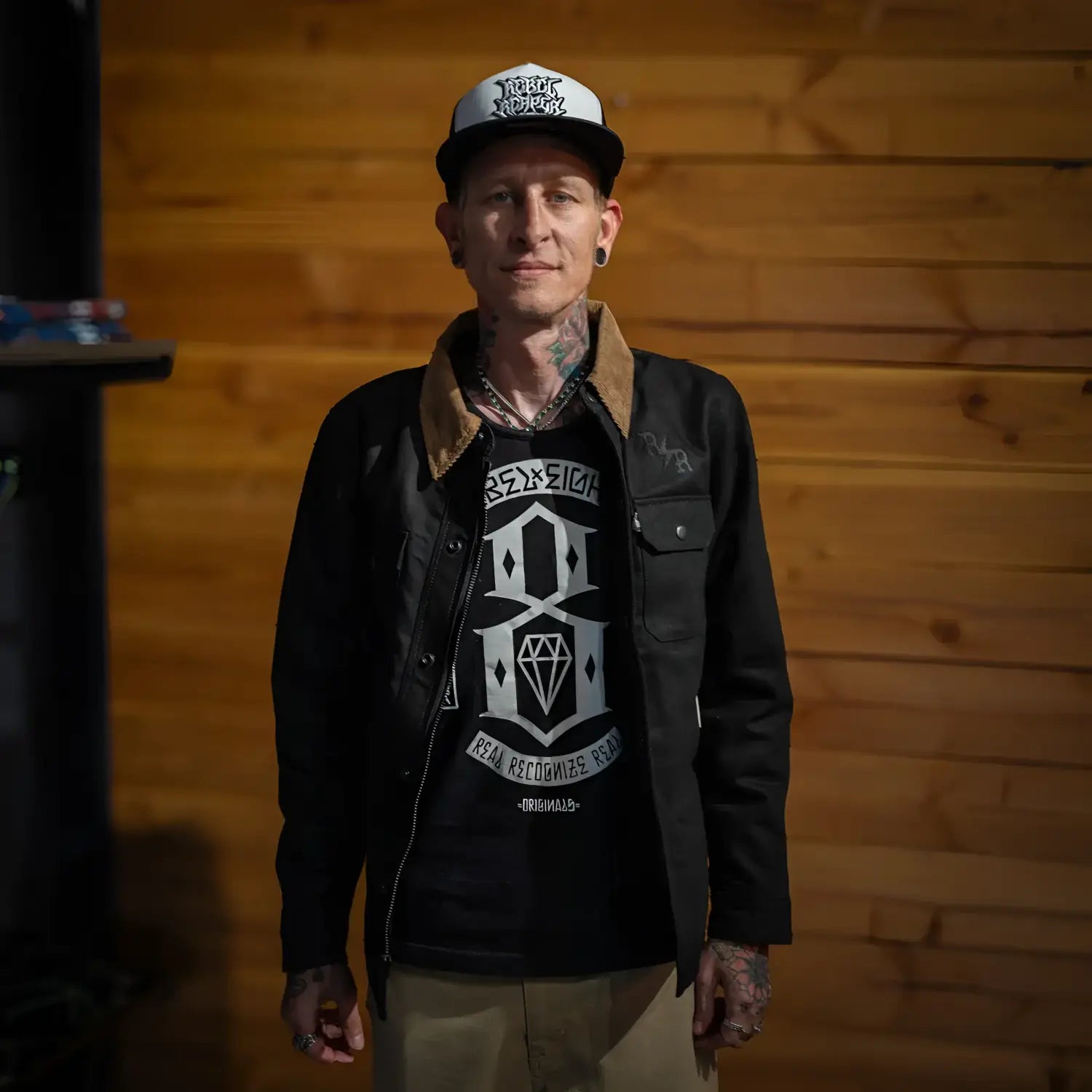 Tattooed man wearing The Scythe Jacket Black Denim with conceal carry pockets and premium selvedge denim