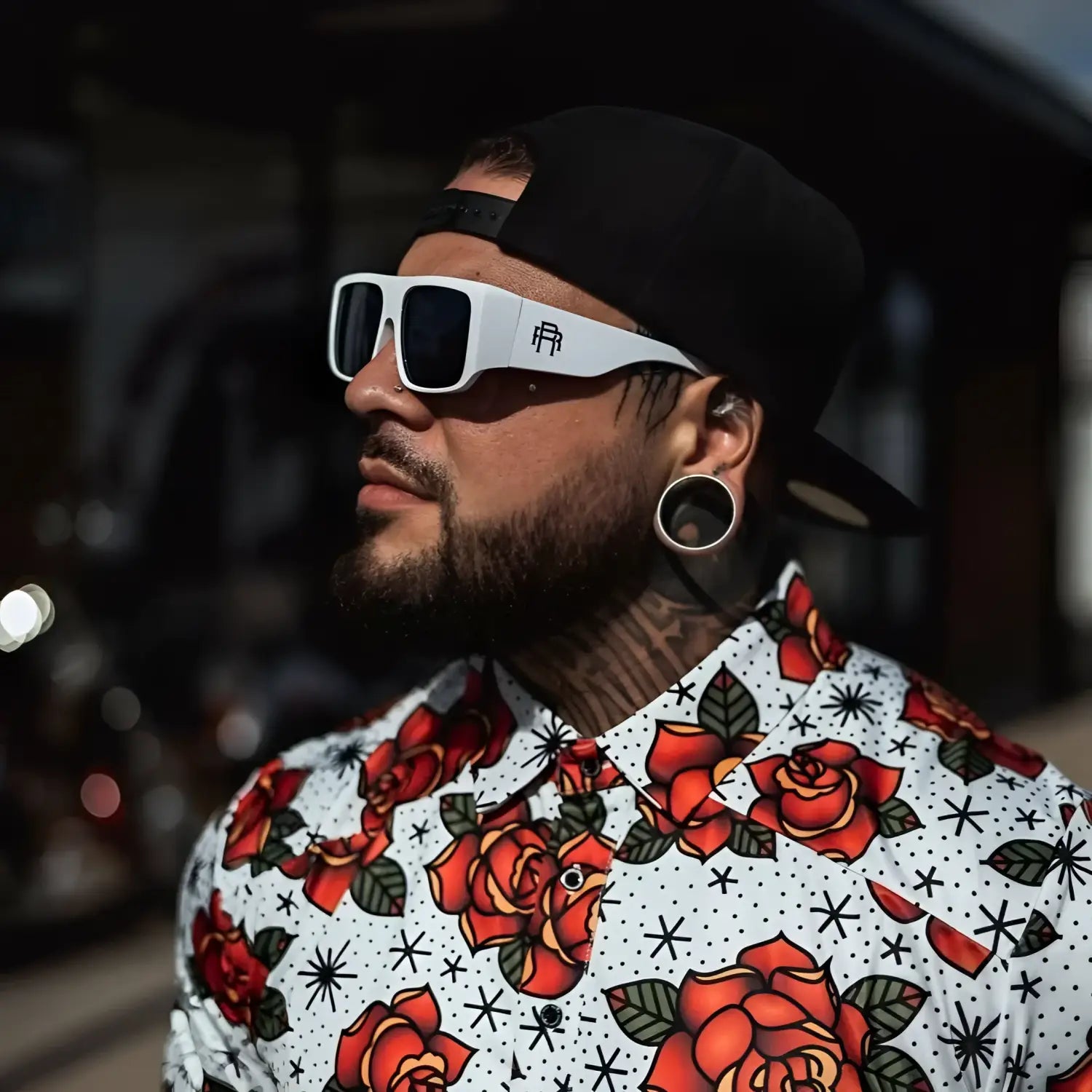 Man with tattoos wearing rose-patterned shirt from Vibe Retro UV400 Sunglass Collection